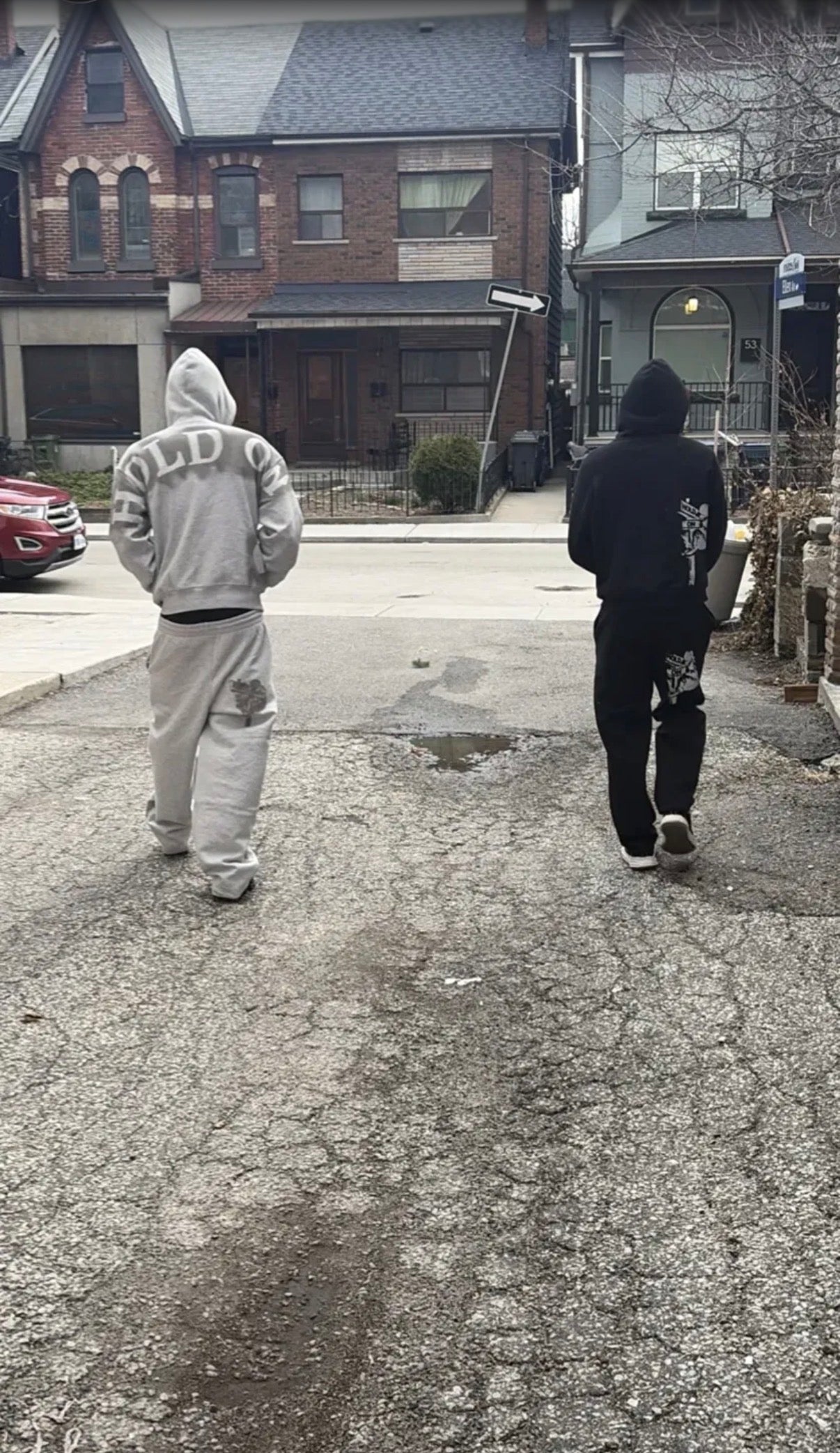 Two people walking away in Hold On Clothing grey and black sets